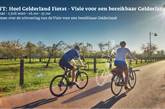 2 fietsers blauwe lucht groen gras