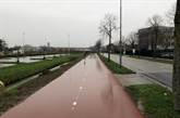 rood asfalt met middenstreep groene grasbermen