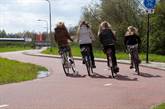 4 Scholieren fietsen naast elkaar